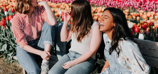 Three women laughing in a park